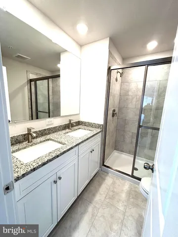 a spacious bathroom with a granite countertop sink mirror and double