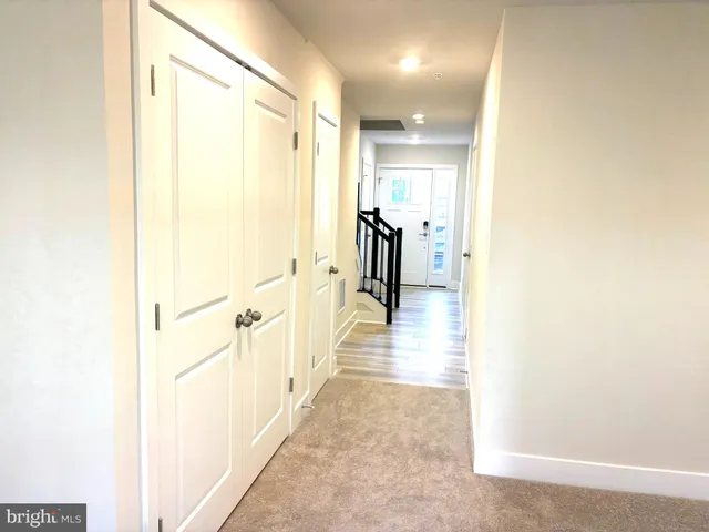 a hallway with wooden floor and closet