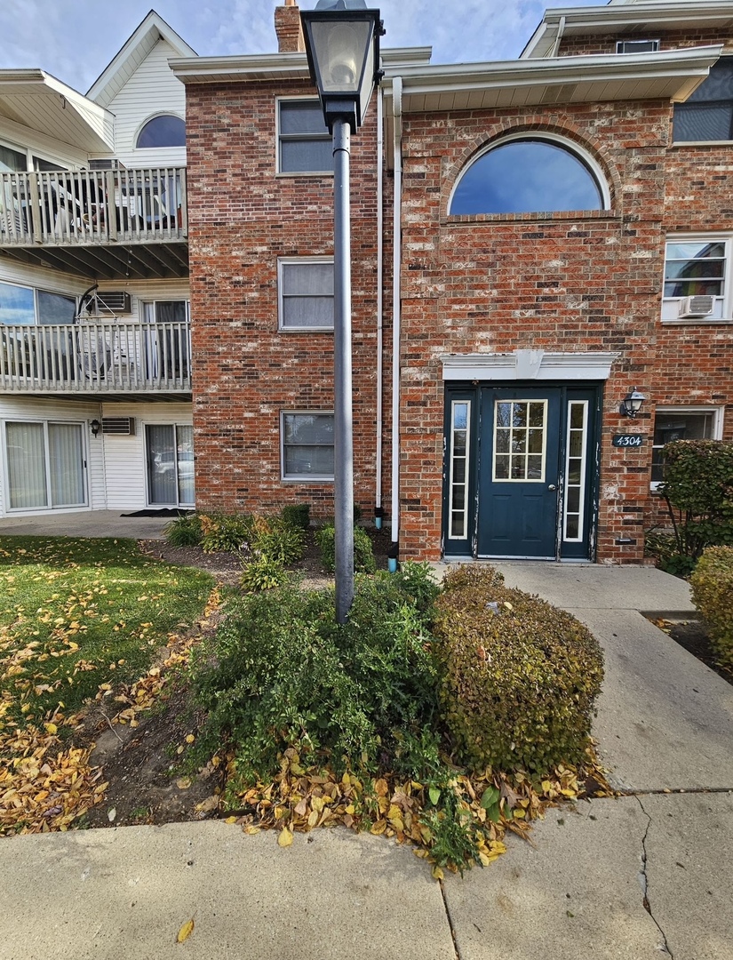 4304 West Shamrock Lane, Unit 1A McHenry, IL 60050 - Photo 2 of 20 a front view of a house with a garden