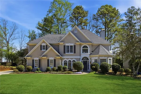 a front view of a house with a yard patio and green space