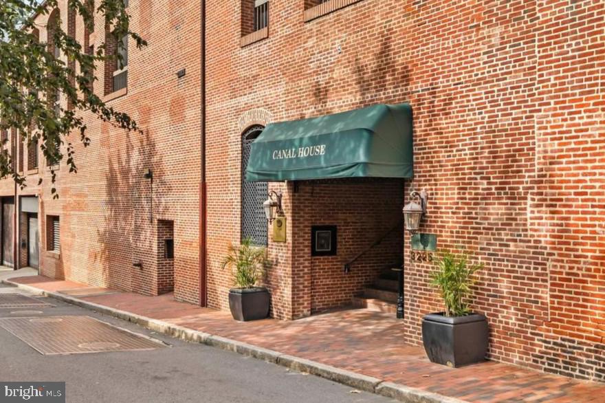 a view of a brick house with a door and wooden floor