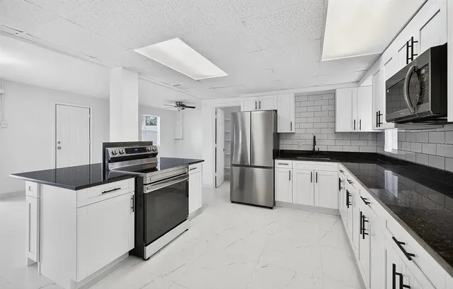 a kitchen with stainless steel appliances a refrigerator stove microwave and sink