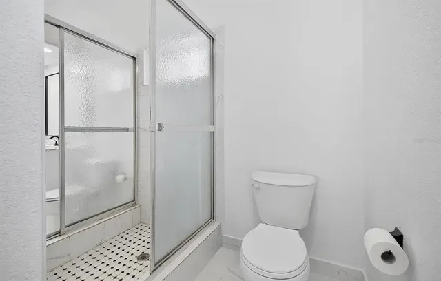 a bathroom with a toilet and a shower