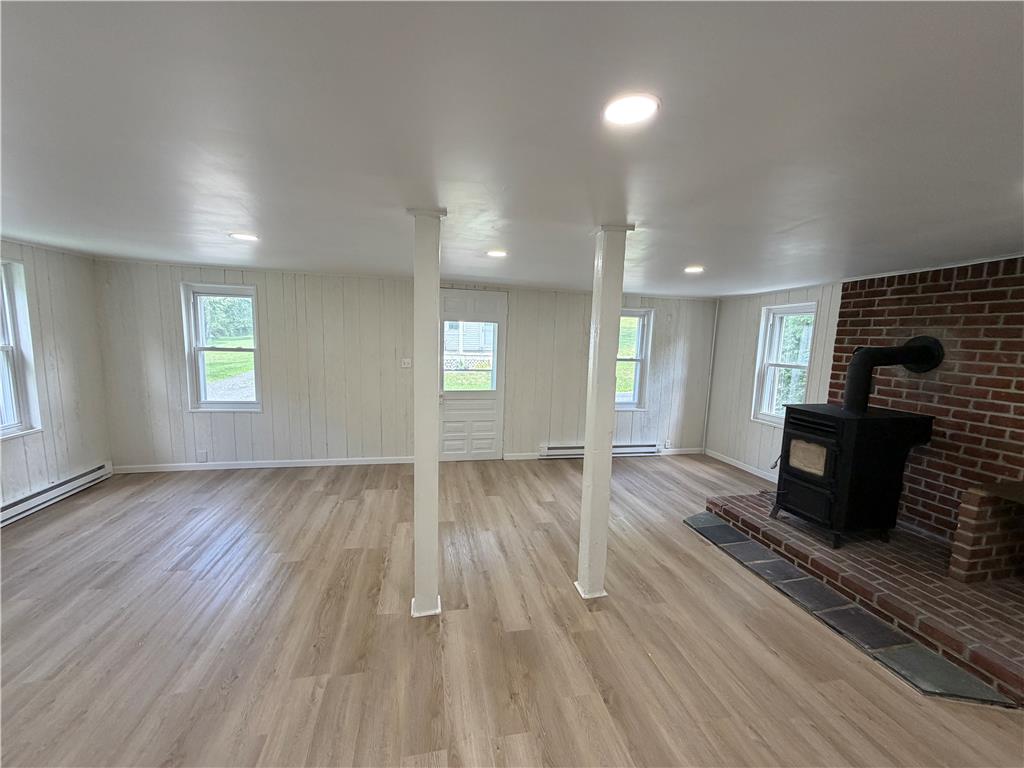 5720 Memorial Road Germansville, PA 18053 - Photo 9 of 30 A welcoming living space features light wood-look flooring and a classic brick fireplace.