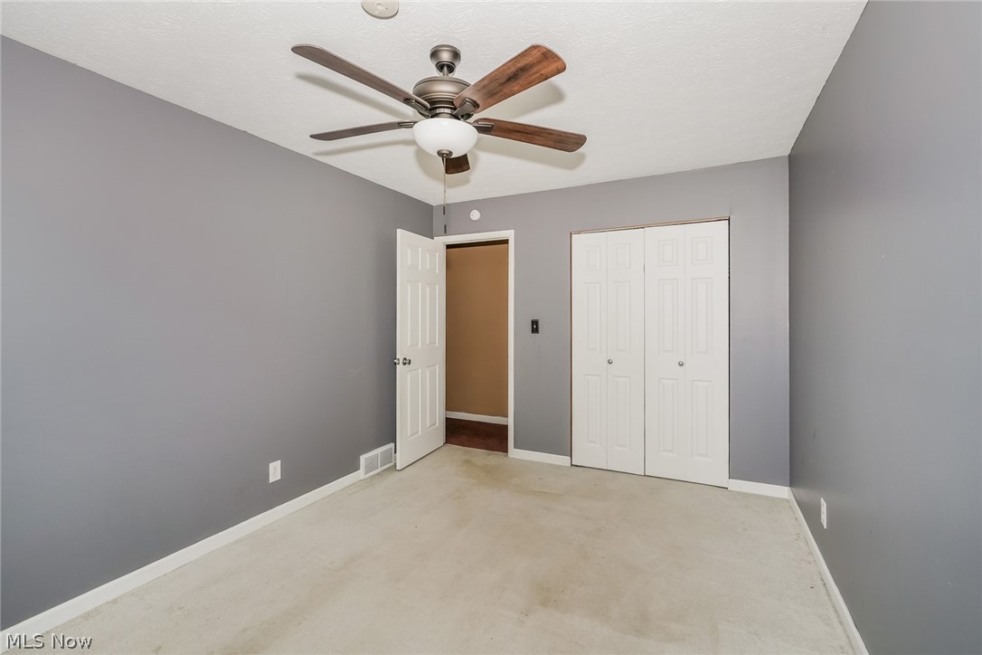 215 Randel Avenue Akron, OH 44313 - Photo 14 of 20 Unfurnished bedroom featuring carpet flooring, a closet, and ceiling fan
