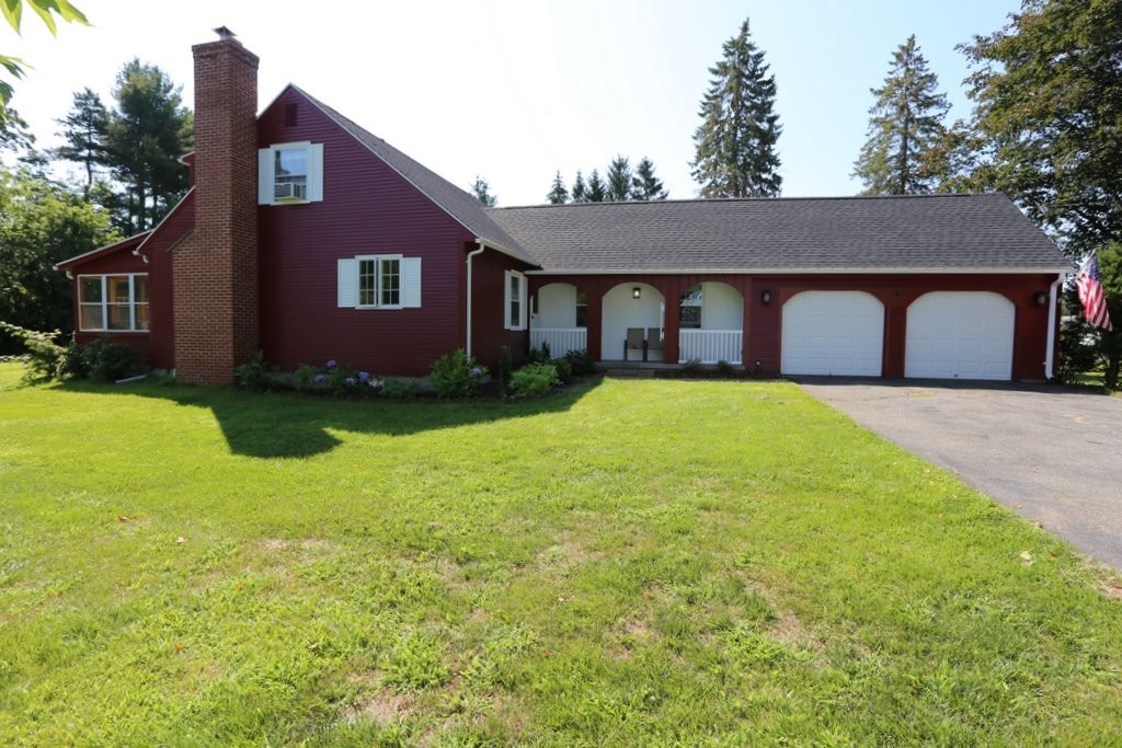 a front view of a house with yard and trees