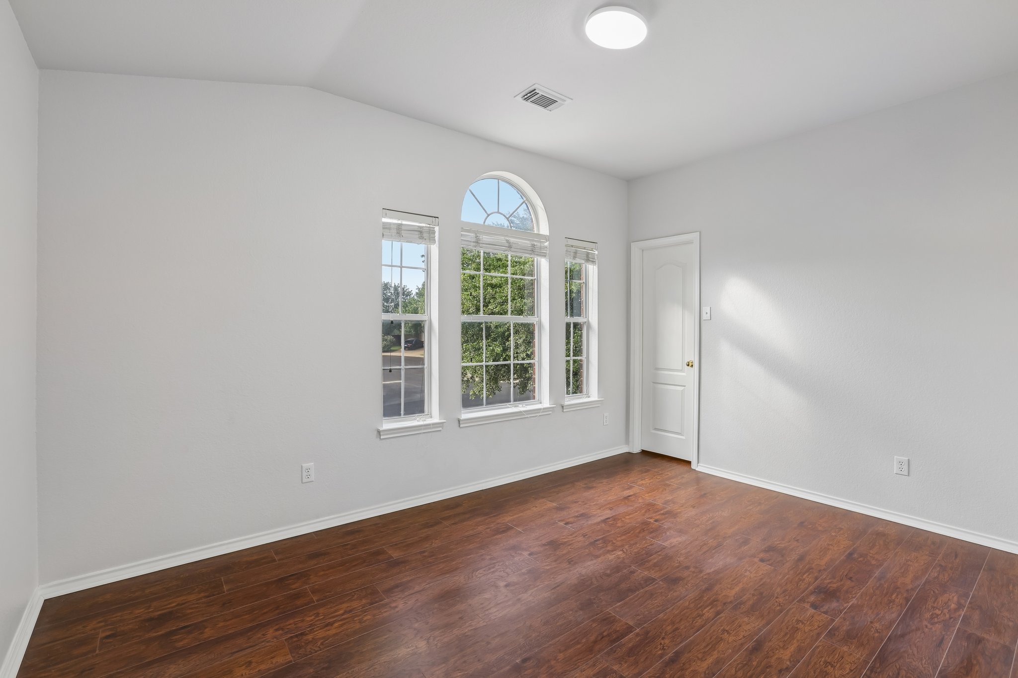 1721 Long Rifle Drive Austin, TX 78754 - Photo 23 of 38 Ample natural light illuminates rich hardwood flooring in this cozy bedroom.