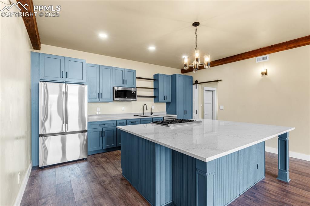 332 Yellow Bird Road Rye, CO 81069 - Photo 9 of 49 a kitchen with kitchen island granite countertop a sink refrigerator and wooden floor