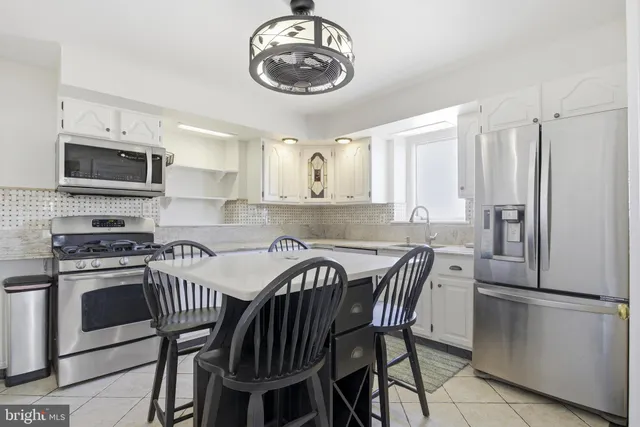 a kitchen with granite countertop a sink a stove and cabinets