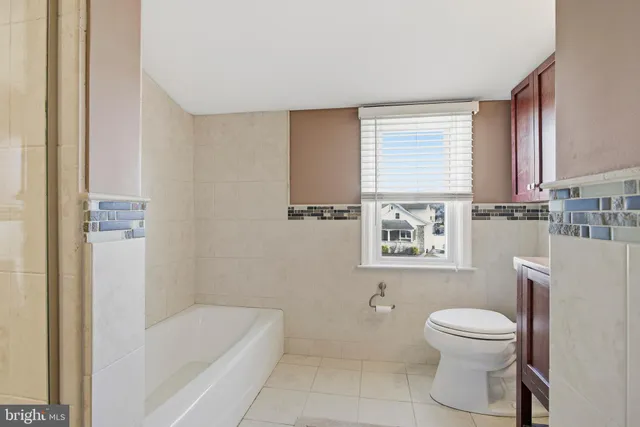 a bathroom with a granite countertop toilet sink and mirror