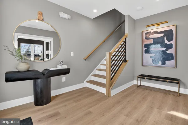 a view of a hallway with wooden floor and a living room