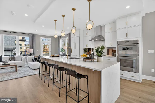 a large kitchen with stainless steel appliances a large counter top a stove and a sink