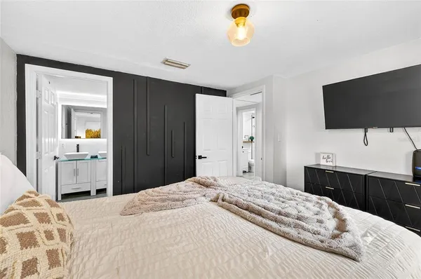 a bedroom with a bed and a flat screen tv