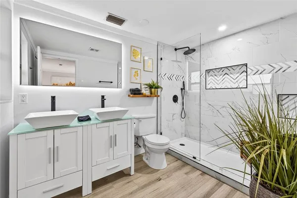 a bathroom with a granite countertop sink a toilet and shower