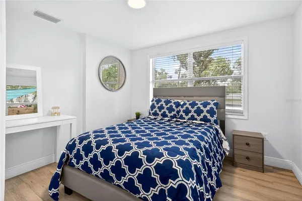 a large bed sitting in a bedroom next to a window