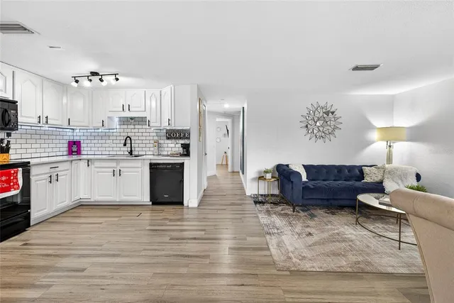 a kitchen with granite countertop a refrigerator stove top oven and sink