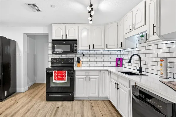 a kitchen with granite countertop a stove top oven a sink and cabinets