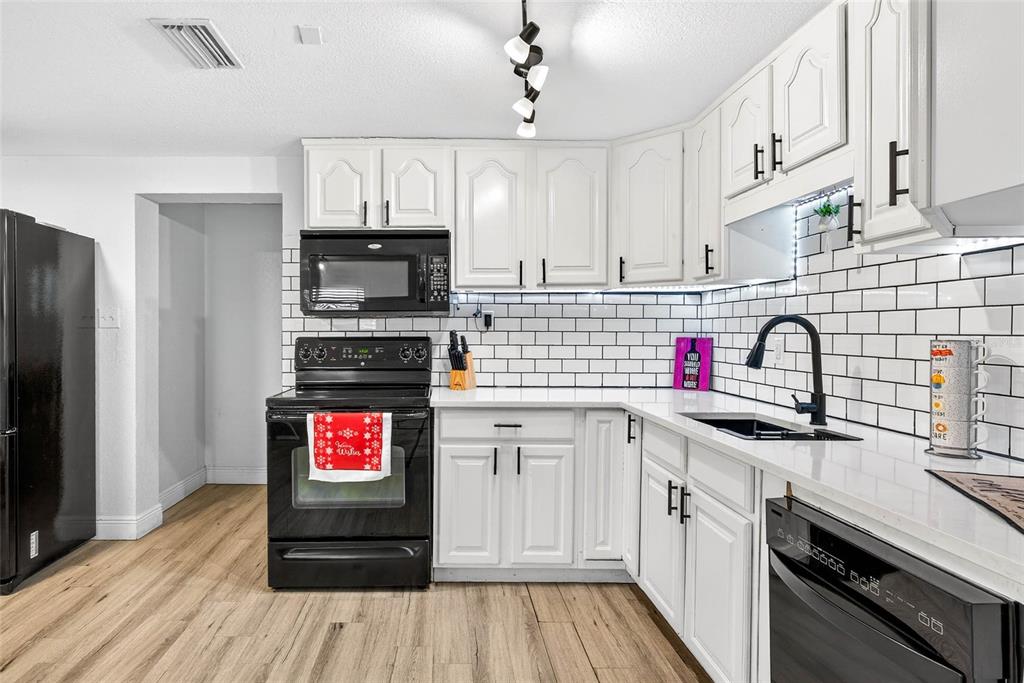 Undisclosed Address Riverview, FL 33578 - Photo 9 of 39 a kitchen with granite countertop a stove top oven a sink and cabinets