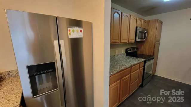 a kitchen with stainless steel appliances granite countertop a refrigerator and a stove