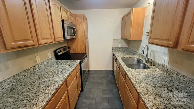a kitchen with a sink stove and microwave