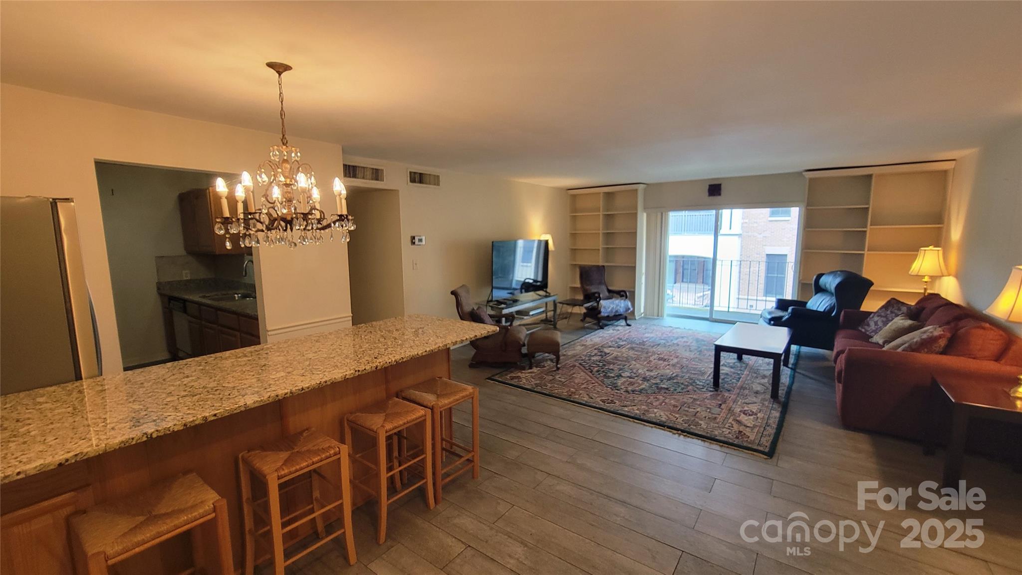 1323 Queens Road, Unit 320 Charlotte, NC 28207 - Photo 2 of 28 a view of a dining room with furniture and a chandelier
