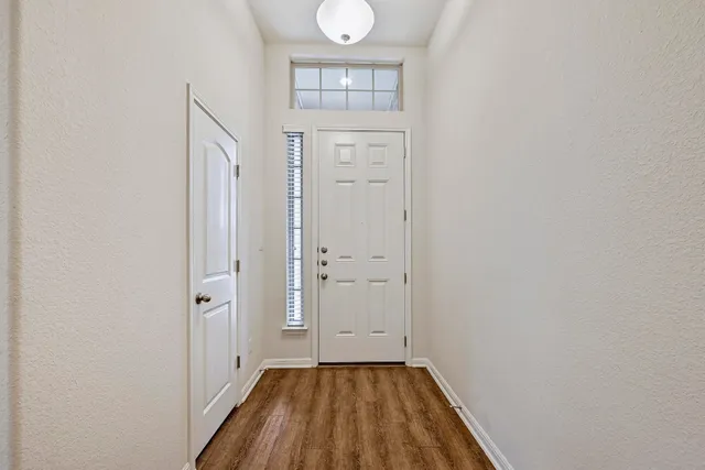 a view of a hallway with wooden floor and closet