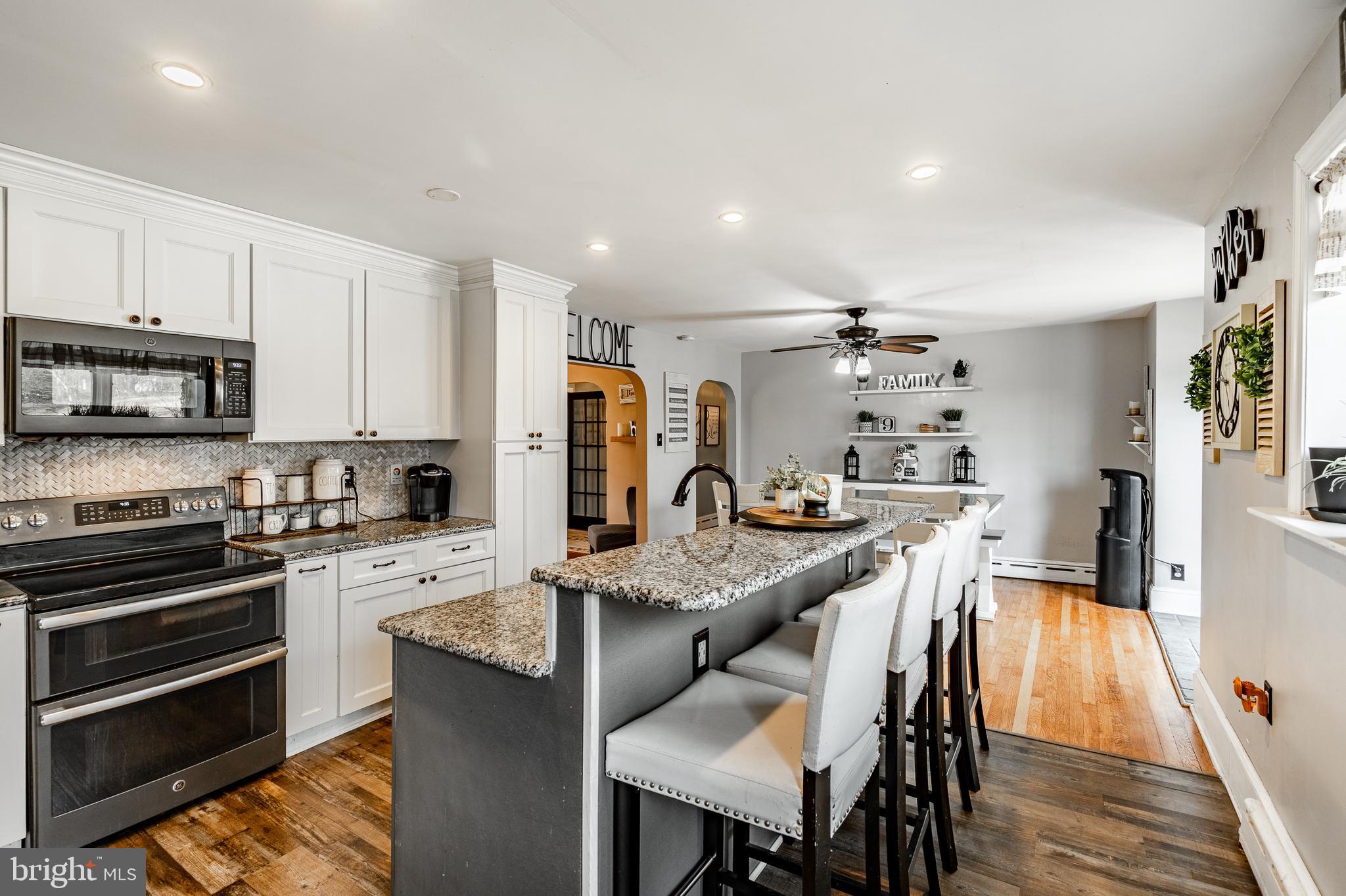 779 Concord Road Glen Mills, PA 19342 - Photo 17 of 64 a kitchen with stainless steel appliances granite countertop a stove a refrigerator a kitchen island with a dining table and chairs
