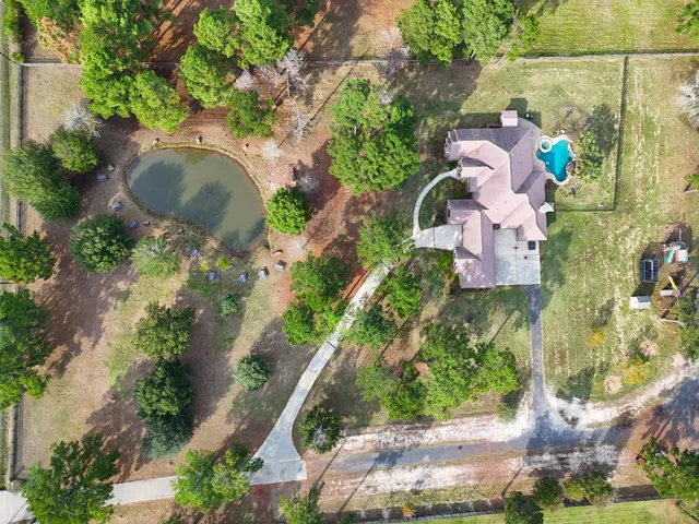 an aerial view of a house with a yard and greenery