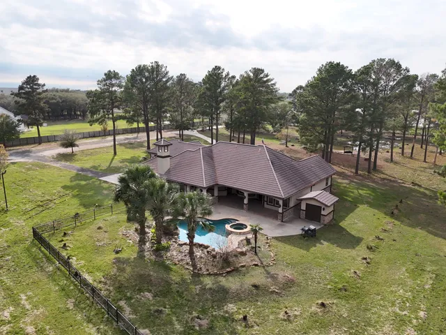 a aerial view of a house with swimming pool and next to a yard