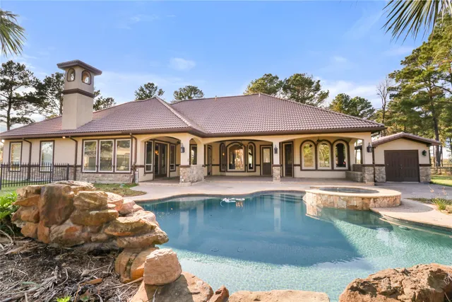 a front view of a house with swimming pool having outdoor seating