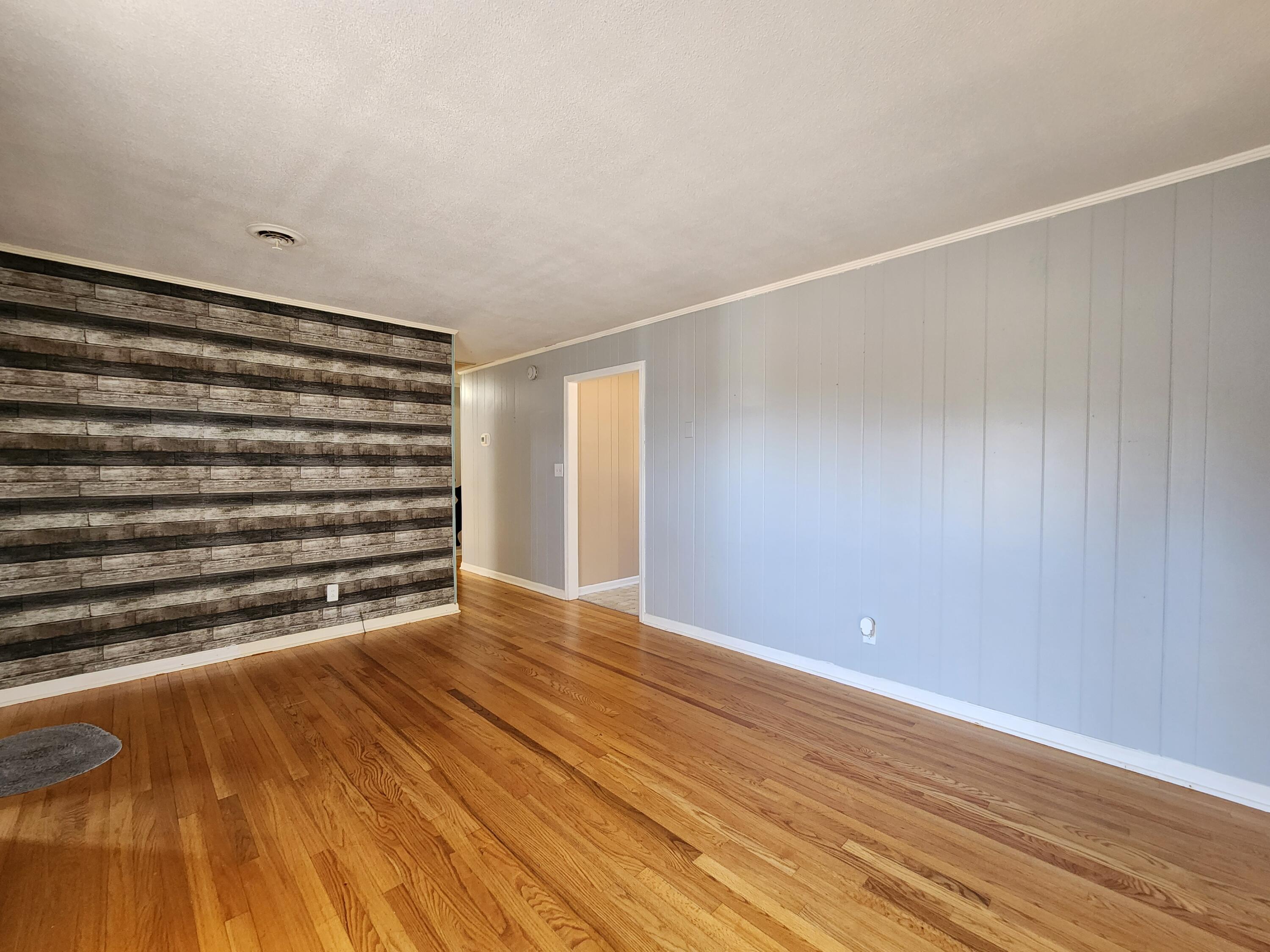 10519 Henry Road Henry, VA 24102 - Photo 6 of 26 a view of an empty room with wooden floor and a window