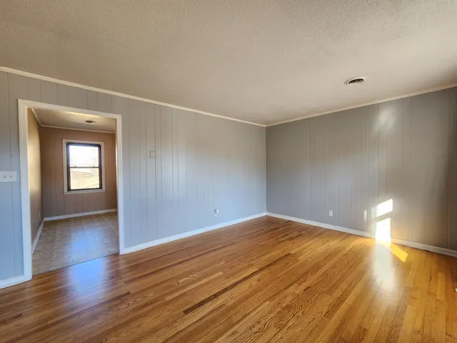 a view of empty room with wooden floor