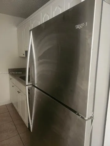 a close view of a sink and dishwasher with white cabinets