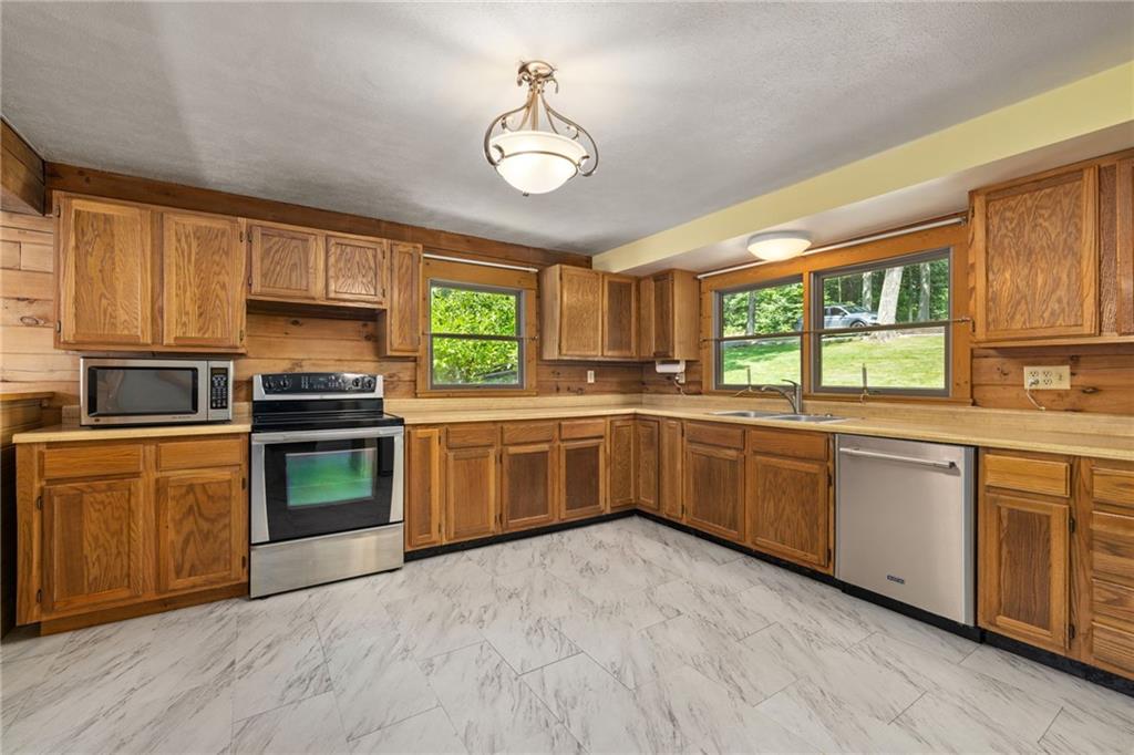 1335 Alamae Lakes Road Washington, PA 15301 - Photo 13 of 50 a kitchen with stainless steel appliances kitchen island granite countertop a stove a sink dishwasher and a microwave oven with cabinets