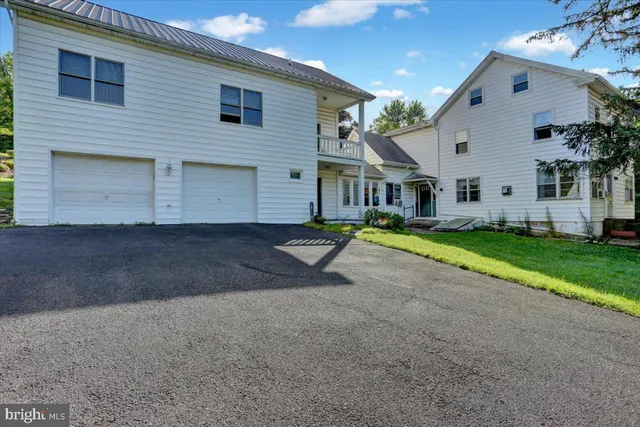 a view of a white house with a yard and plants