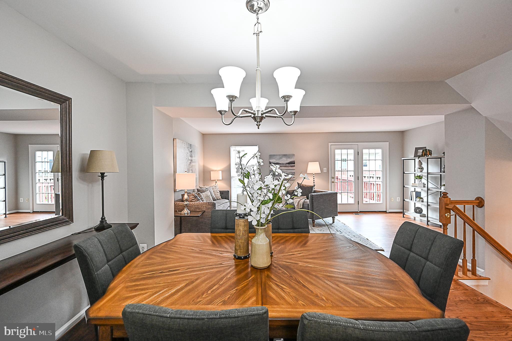 6356 Racetec Place Springfield, VA 22150 - Photo 13 of 51 a view of a dining room with furniture a chandelier and wooden floor