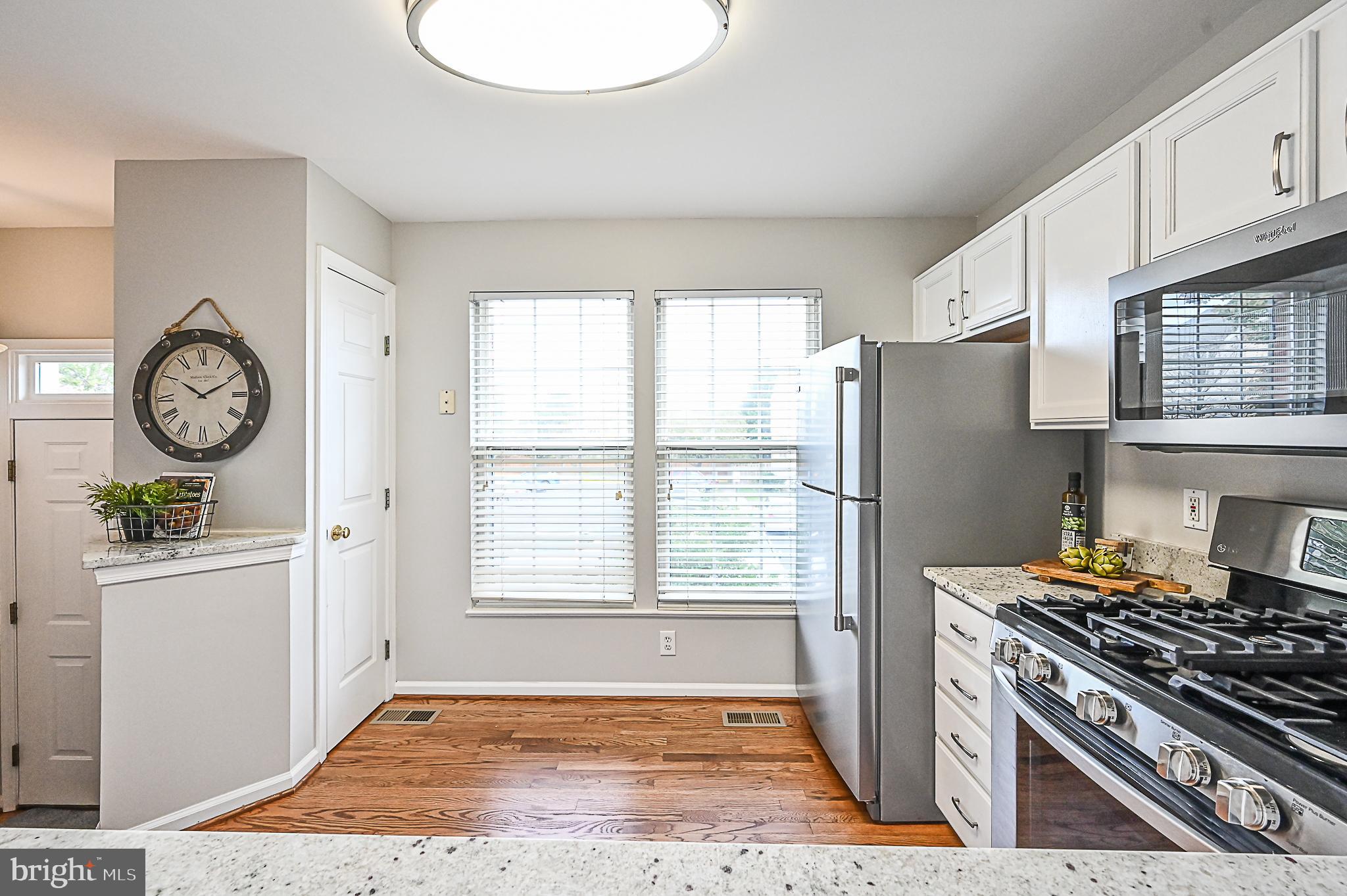 6356 Racetec Place Springfield, VA 22150 - Photo 14 of 51 a kitchen with stainless steel appliances granite countertop a refrigerator a stove and a window