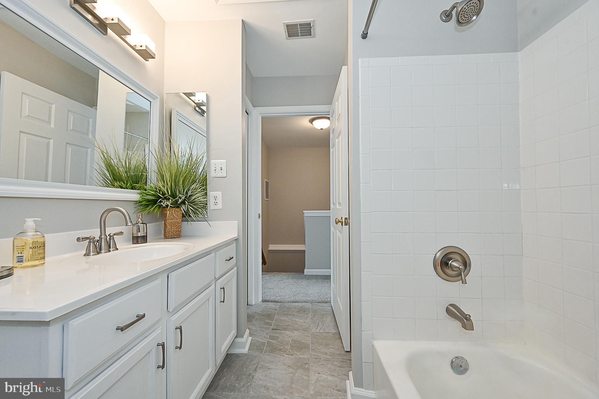 6356 Racetec Place Springfield, VA 22150 - Photo 38 of 51 a bathroom with a bathtub sink a mirror and vanity