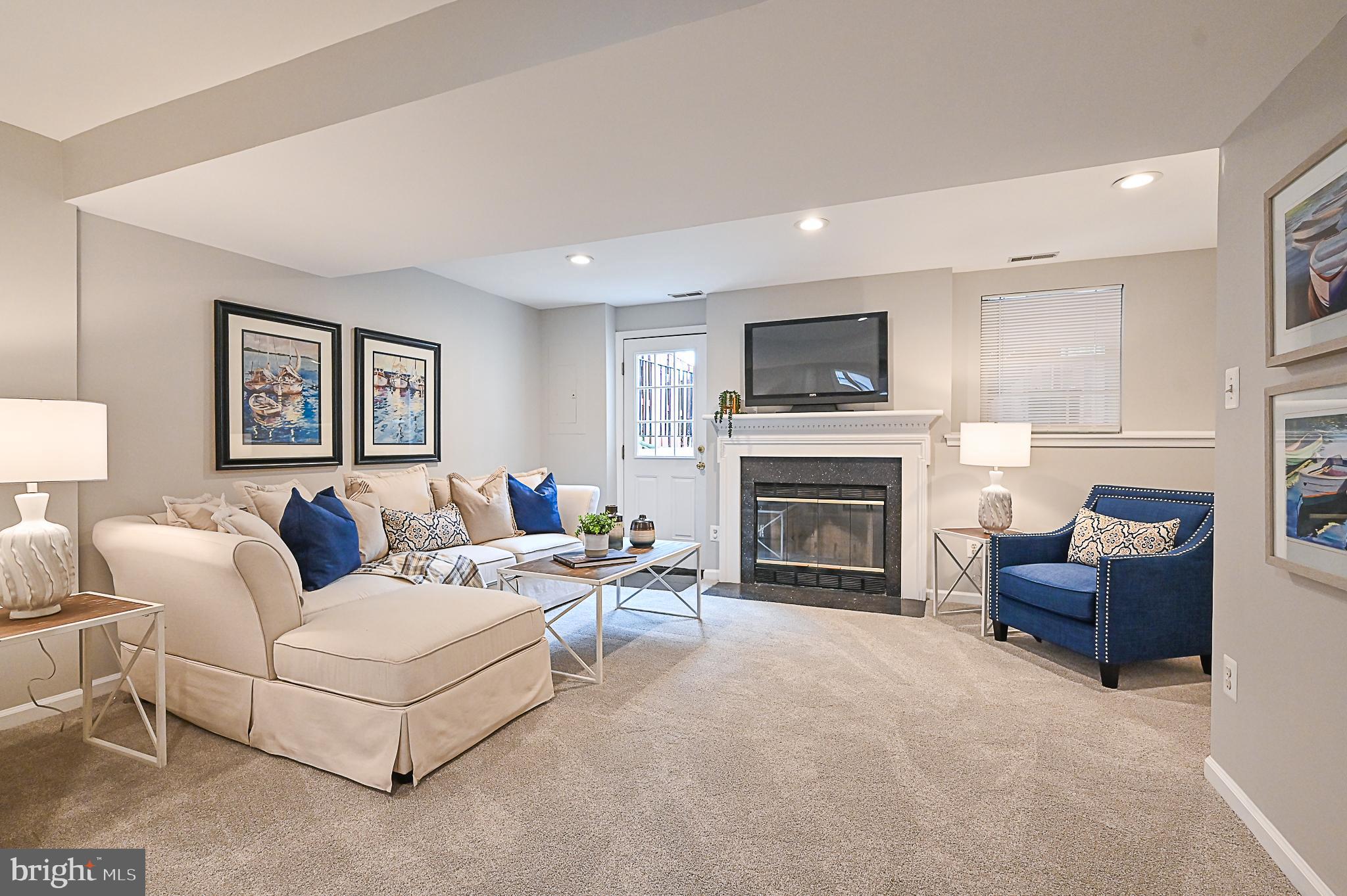 6356 Racetec Place Springfield, VA 22150 - Photo 39 of 51 a living room with furniture a fireplace and a flat screen tv