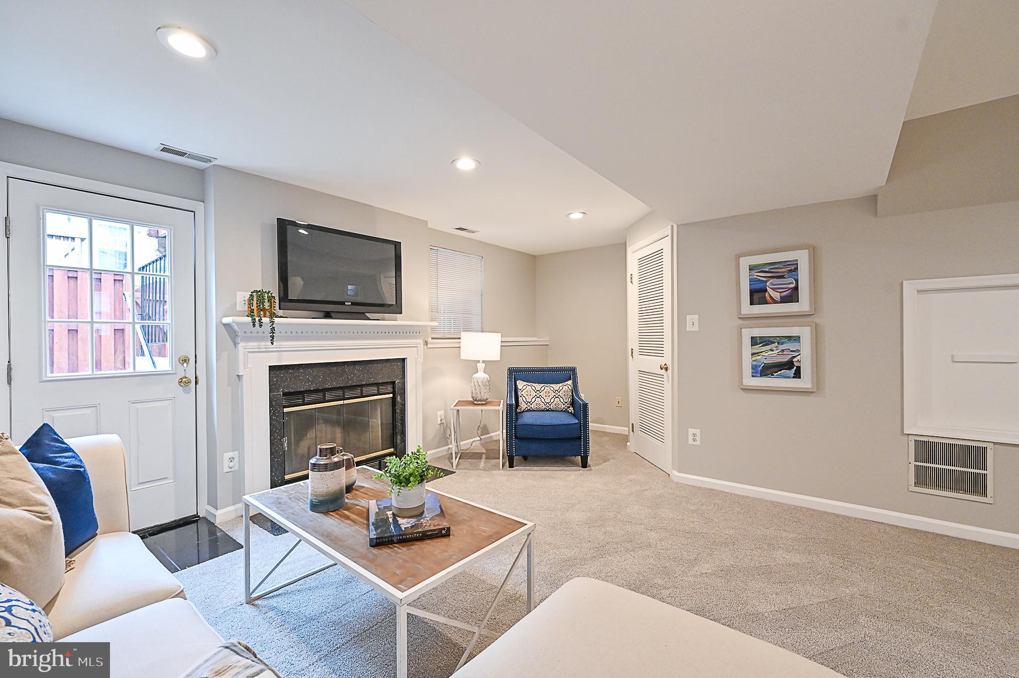 6356 Racetec Place Springfield, VA 22150 - Photo 41 of 51 a living room with furniture a fireplace and a flat screen tv