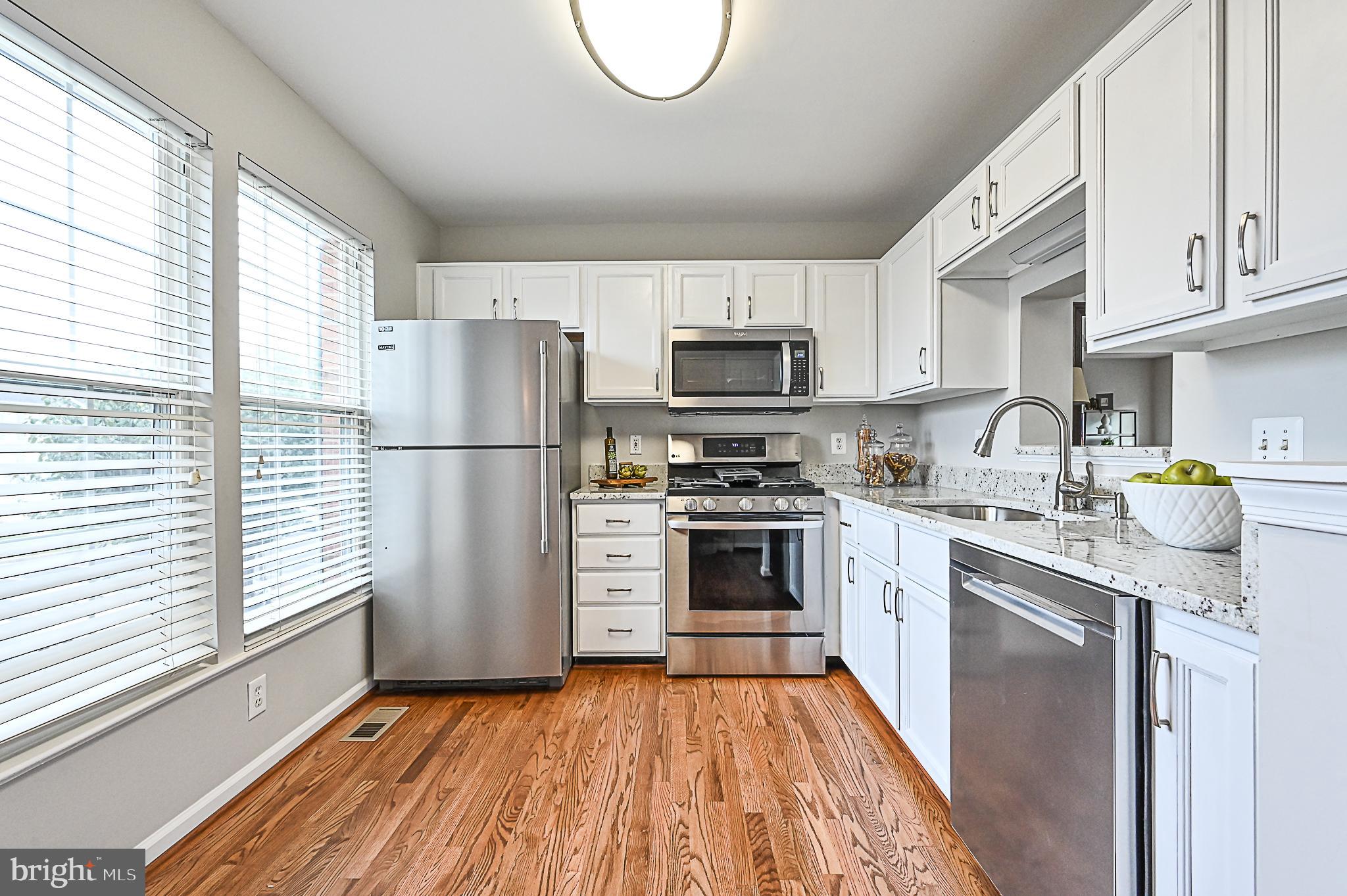 6356 Racetec Place Springfield, VA 22150 - Photo 10 of 51 a kitchen with stainless steel appliances a refrigerator sink and microwave