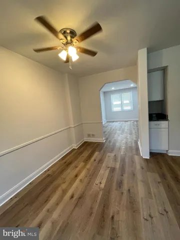 a view of a livingroom with wooden floor and a ceiling fan