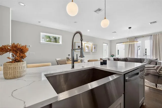 a kitchen with a sink a counter and chairs