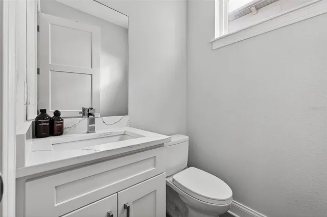 a bathroom with a toilet a sink and mirror