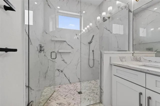 a bathroom with a sink shower and a mirror
