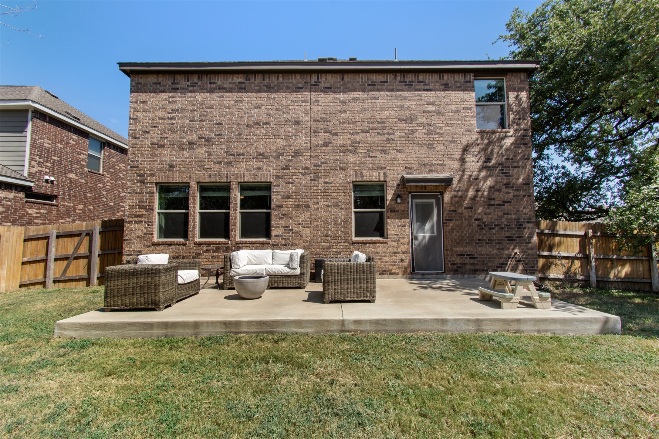 904 American Trail, Unit 2 Leander, TX 78641 - Photo 24 of 29 Rear view of house with a fenced backyard, a patio area, and brick siding