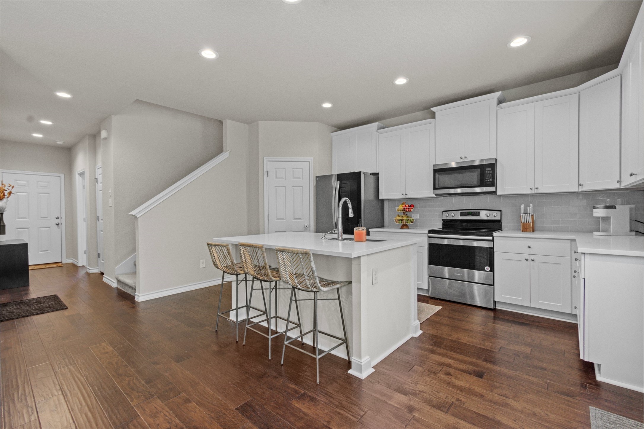 904 American Trail, Unit 2 Leander, TX 78641 - Photo 7 of 29 Kitchen with stainless steel appliances, recessed lighting, white cabinetry, a center island with sink, and decorative backsplash.