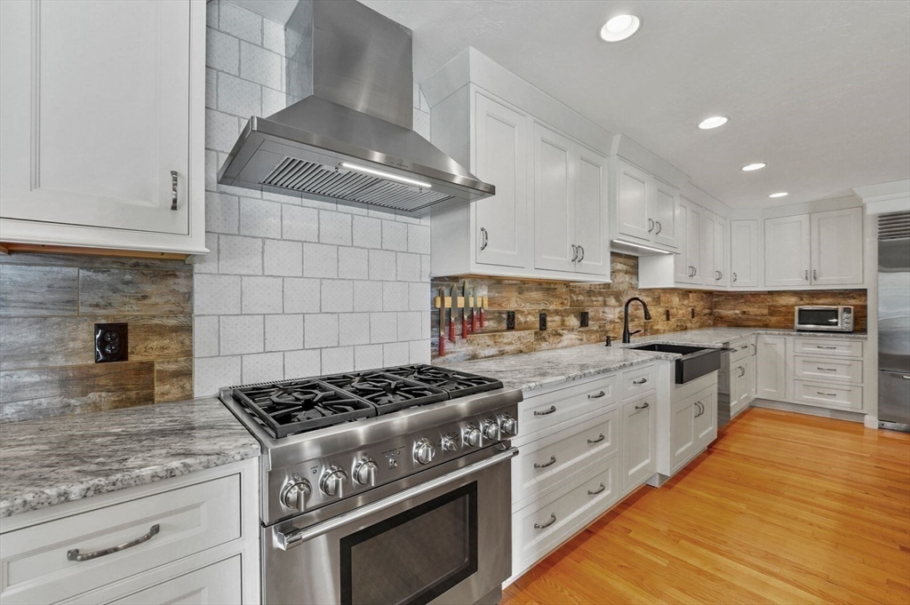 31 Douglas Road Sutton, MA 01590 - Photo 11 of 42 a kitchen with stainless steel appliances granite countertop a stove and white cabinets
