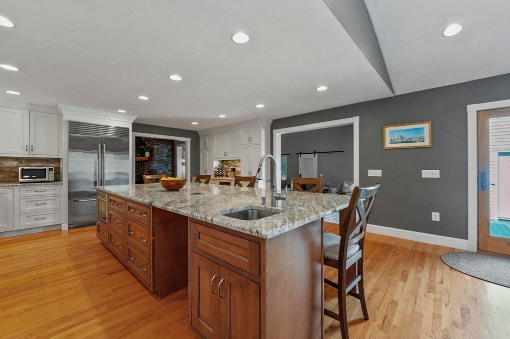 31 Douglas Road Sutton, MA 01590 - Photo 14 of 42 a kitchen with stainless steel appliances granite countertop a kitchen island a stove a sink a dining table and chairs