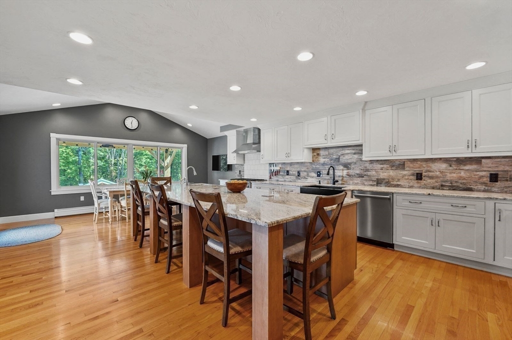 31 Douglas Road Sutton, MA 01590 - Photo 10 of 42 a kitchen with a dining table chairs wooden floor cabinets and stainless steel appliances